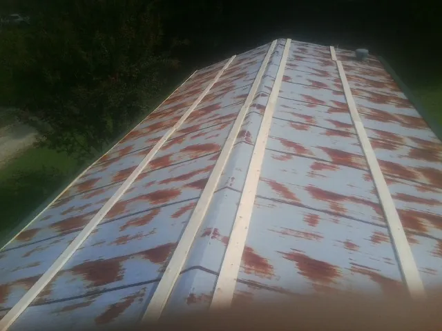 Rusted metal roof panels with new wood purlins before replacement — Storm Damage Roof Repair in Fruitland by Roofing Brothers